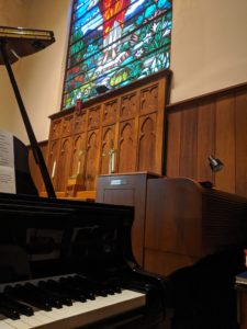 Pretty stained glass behind the piano