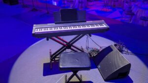 Close-up of piano under warm spotlights at the Baltimore Choral Arts Society event.